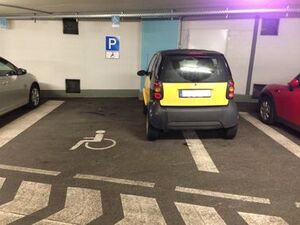 Zwei Fliegen mit einer Klappe: Behindertenparkplatz und Fluchtweg mit Smart zugeparkt